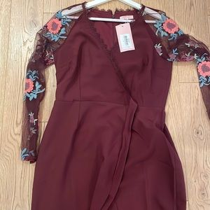 Never been worn women size 10 burgundy dress with sleeves that have flowers.